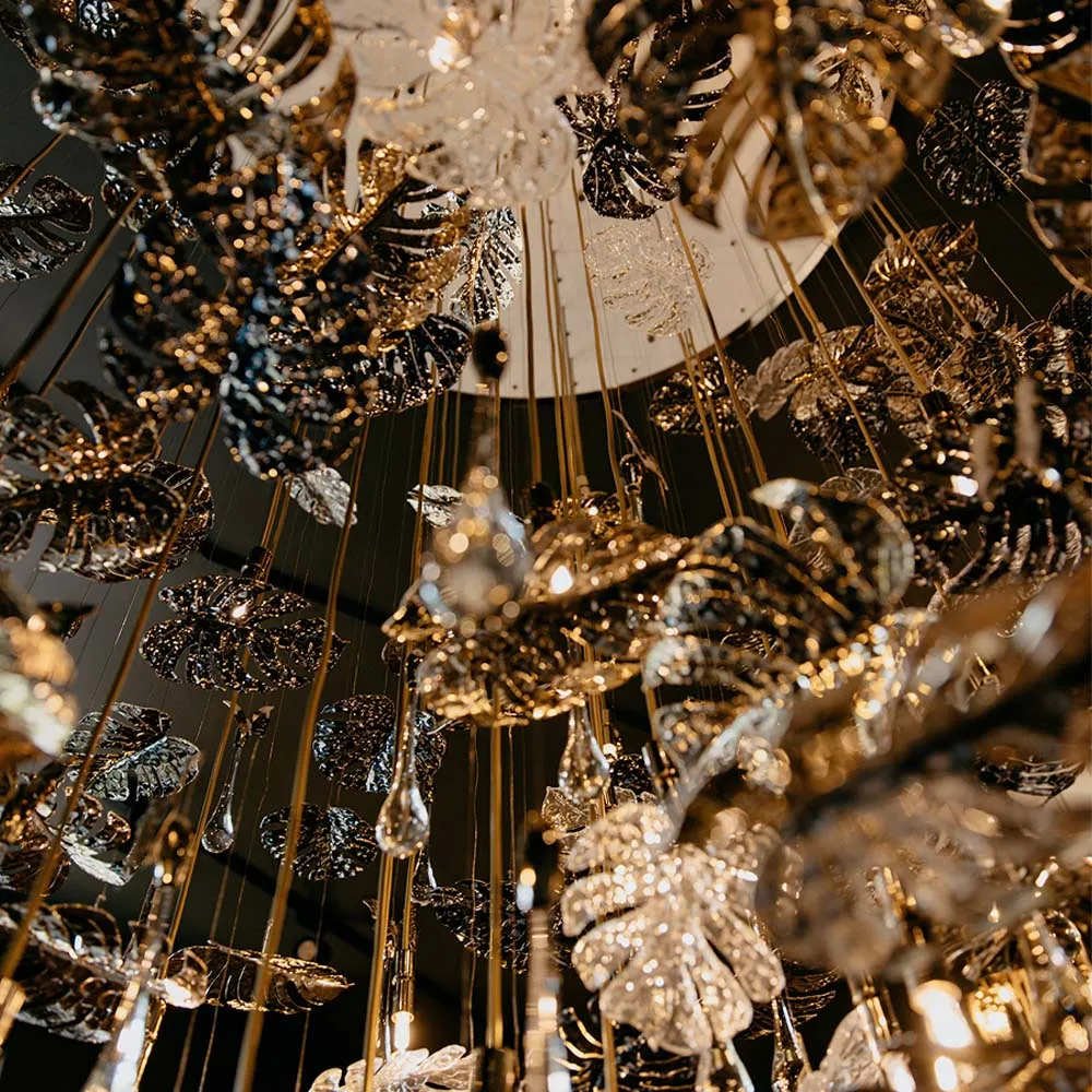 /storage/Luxury brass suspension with nature-inspired raindrop and butterfly details by Castro Lighting.