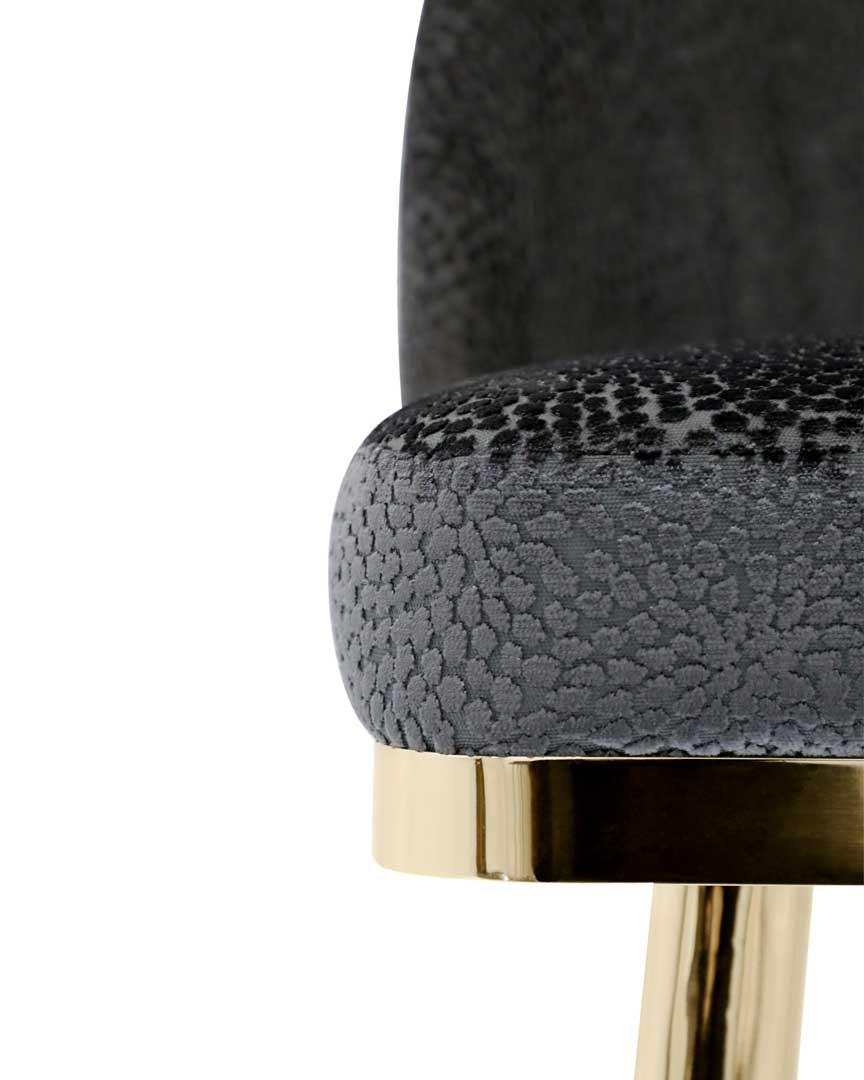 /storage/Luxury brass bar chair with gold-plated legs, black nickel accents, and curved upholstered body, blending Art Deco style with modern femininity.