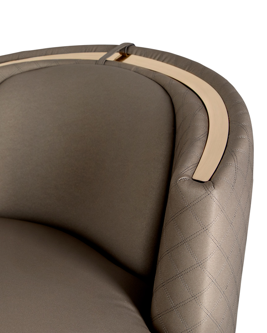 /storage/Luxury brass-accented modern lounge armchair with quilted padded fabric and smooth curves, combining comfort and elegance