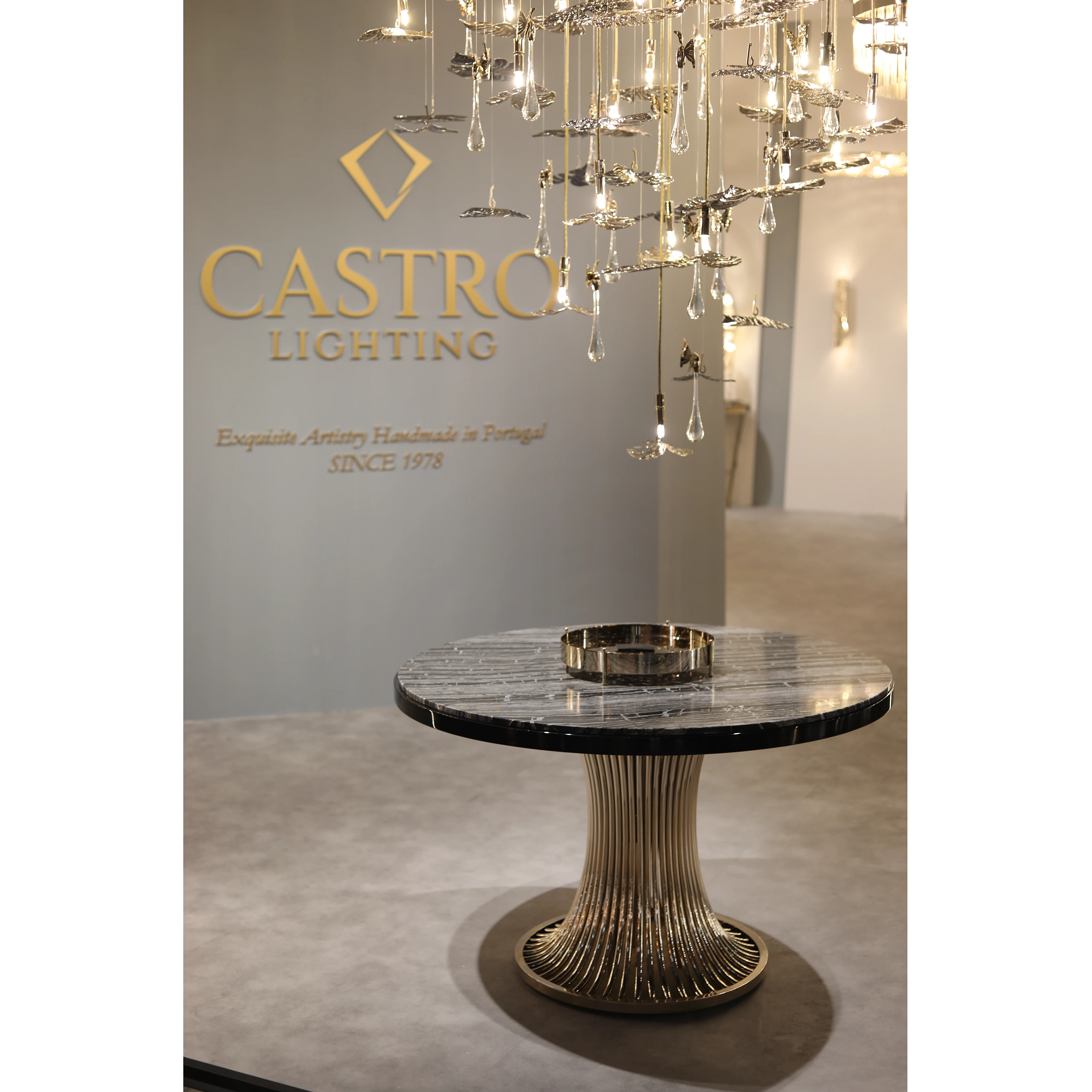/storage/Luxury brass suspension with nature-inspired raindrop and butterfly details by Castro Lighting.