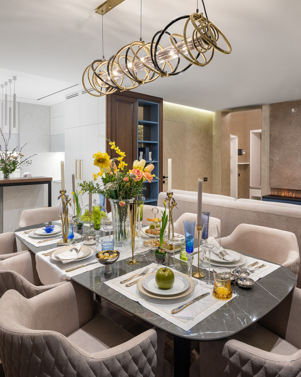 Luxury Residential project by a talented Ukrainian interior designer Svetlana Krasilnikova presents a modern dining room space featuring Castro Lighting's Galaxy Suspension, with its structure mixed in golden brass and black nickel, presents rounded forms carefully handcrafted. Its distinctive silhouette creates an unpredictable effect, reminiscent of the endless enigmas of the cosmos, granting this lighting design an organic and exclusive shape.