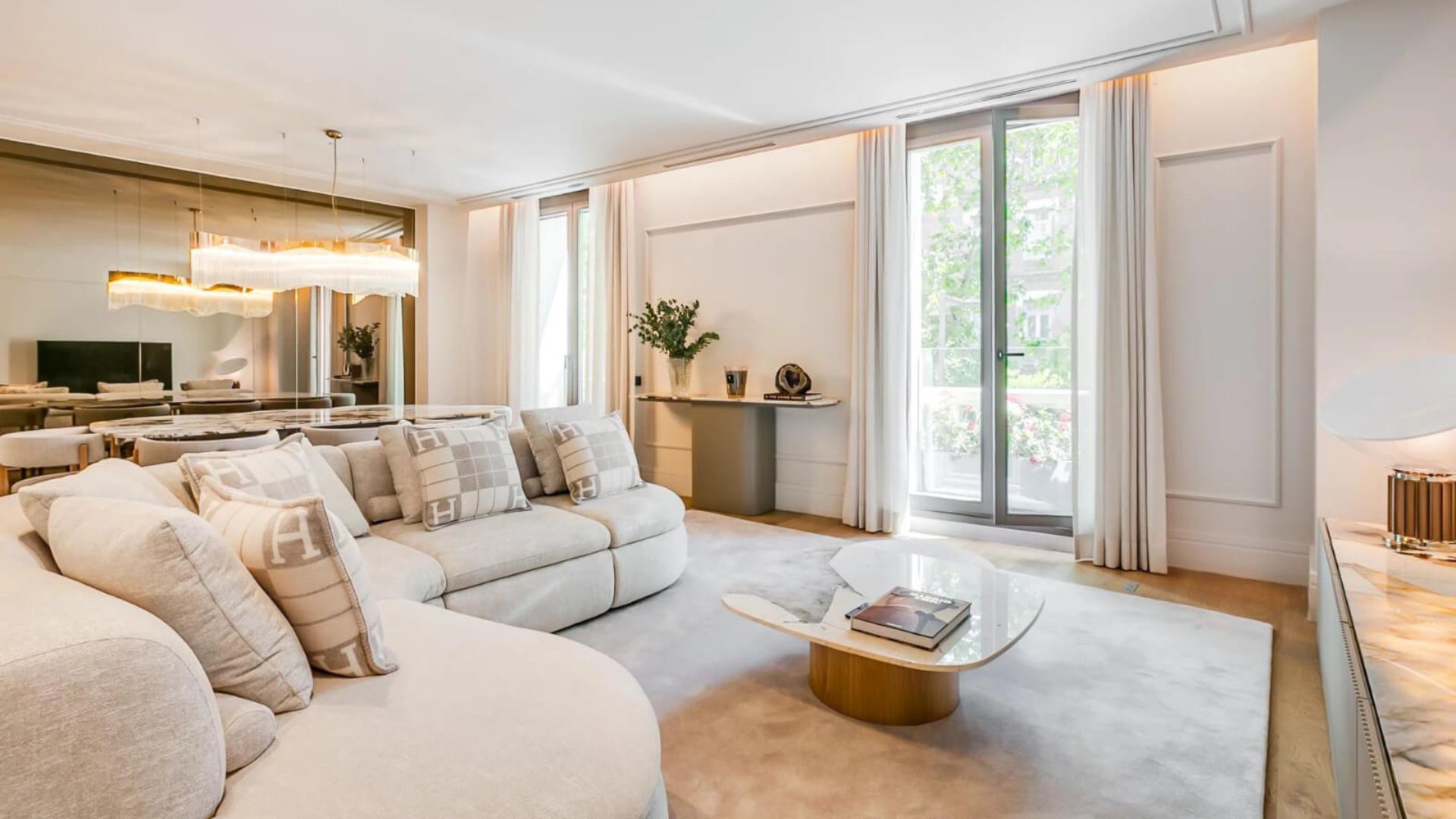 Open plan living space in Georgina Rodríguez’s Madrid apartment, featuring pale wood flooring, neutral tones, and Nordic-inspired minimalism.