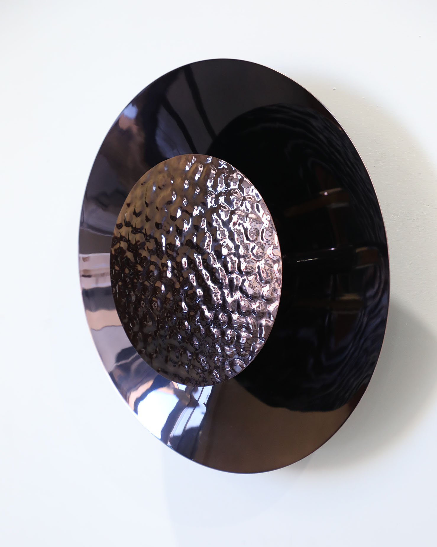 Eclipse Wall Light in Violet Noir pairs sculptural elegance with a refined, atmospheric finish. Its layered brass silhouette casts soft, ambient light, while the Violet Noir tone brings depth and sophistication — shifting subtly between graphite and violet depending on the angle and illumination.