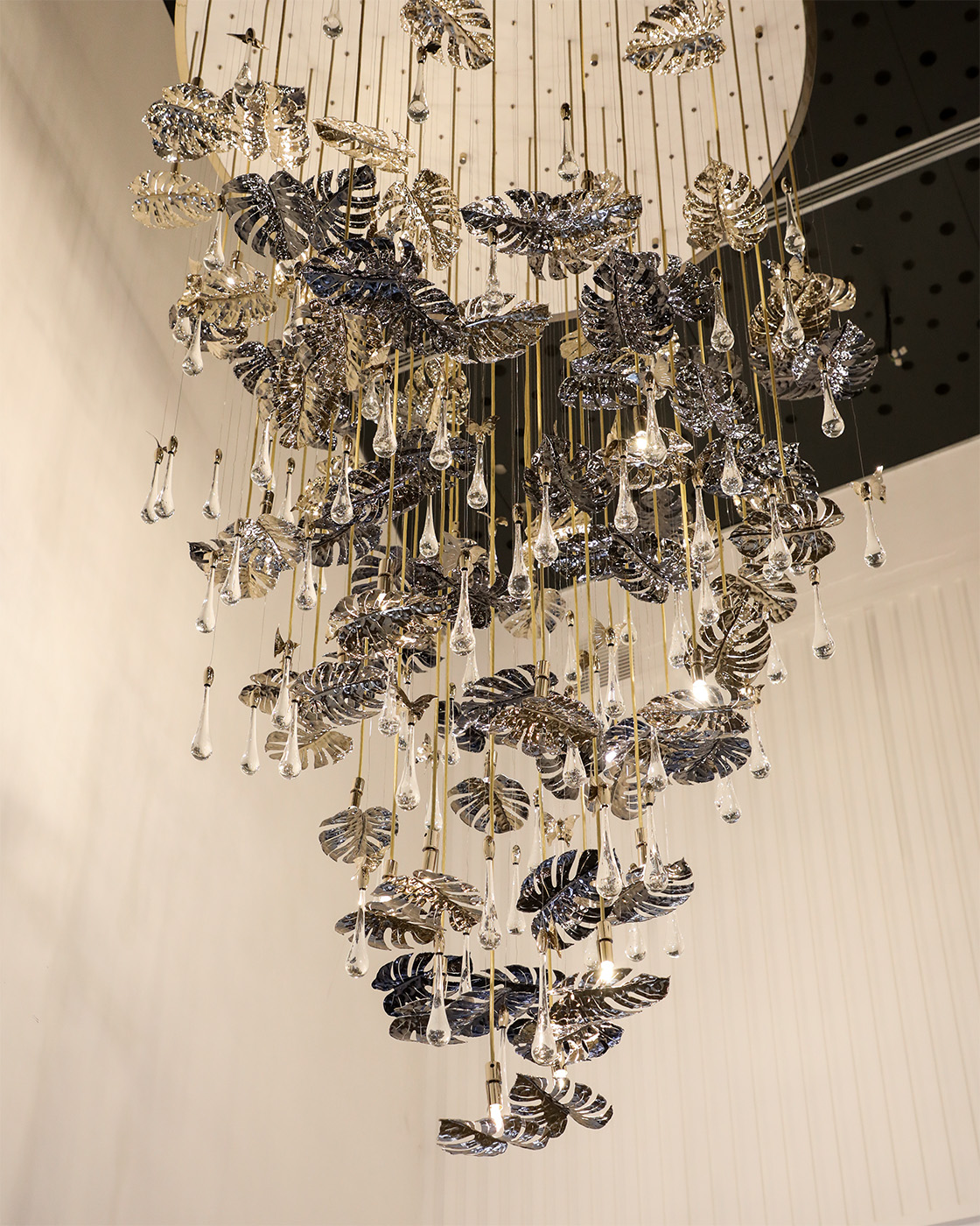 Rainforest Suspension chandelier by Castro Lighting cascading through a modern staircase at the Porto showroom, creating a elegant centerpiece.