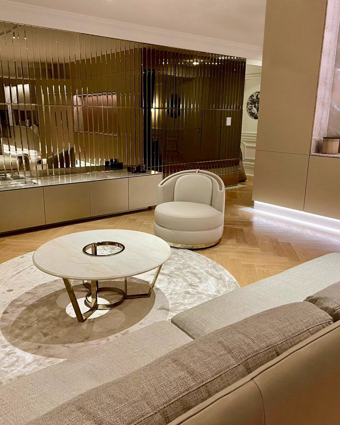 /storage/Luxury brass-accented modern lounge armchair with quilted padded fabric and smooth curves, combining comfort and elegance