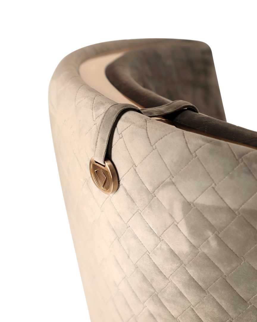 /storage/Luxury brass-accented modern lounge armchair with quilted padded fabric and smooth curves, combining comfort and elegance