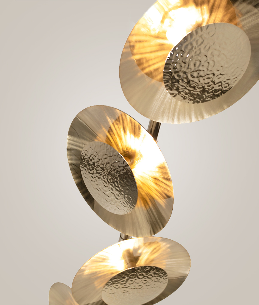 /storage/Luxury brass Eclipse floor lamp with hand-hammered rounded brass plates and gold-plated finish, radiating a warm modern glow.