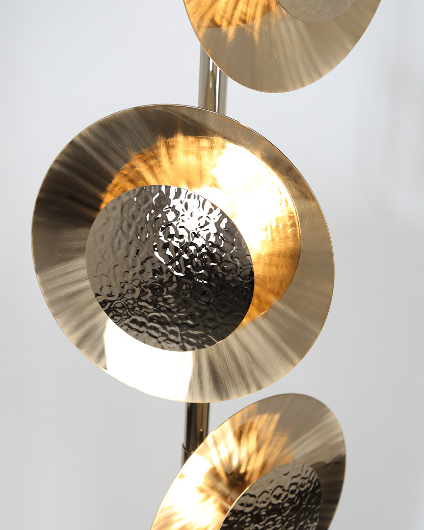 /storage/Luxury brass Eclipse floor lamp with hand-hammered rounded brass plates and gold-plated finish, radiating a warm modern glow.