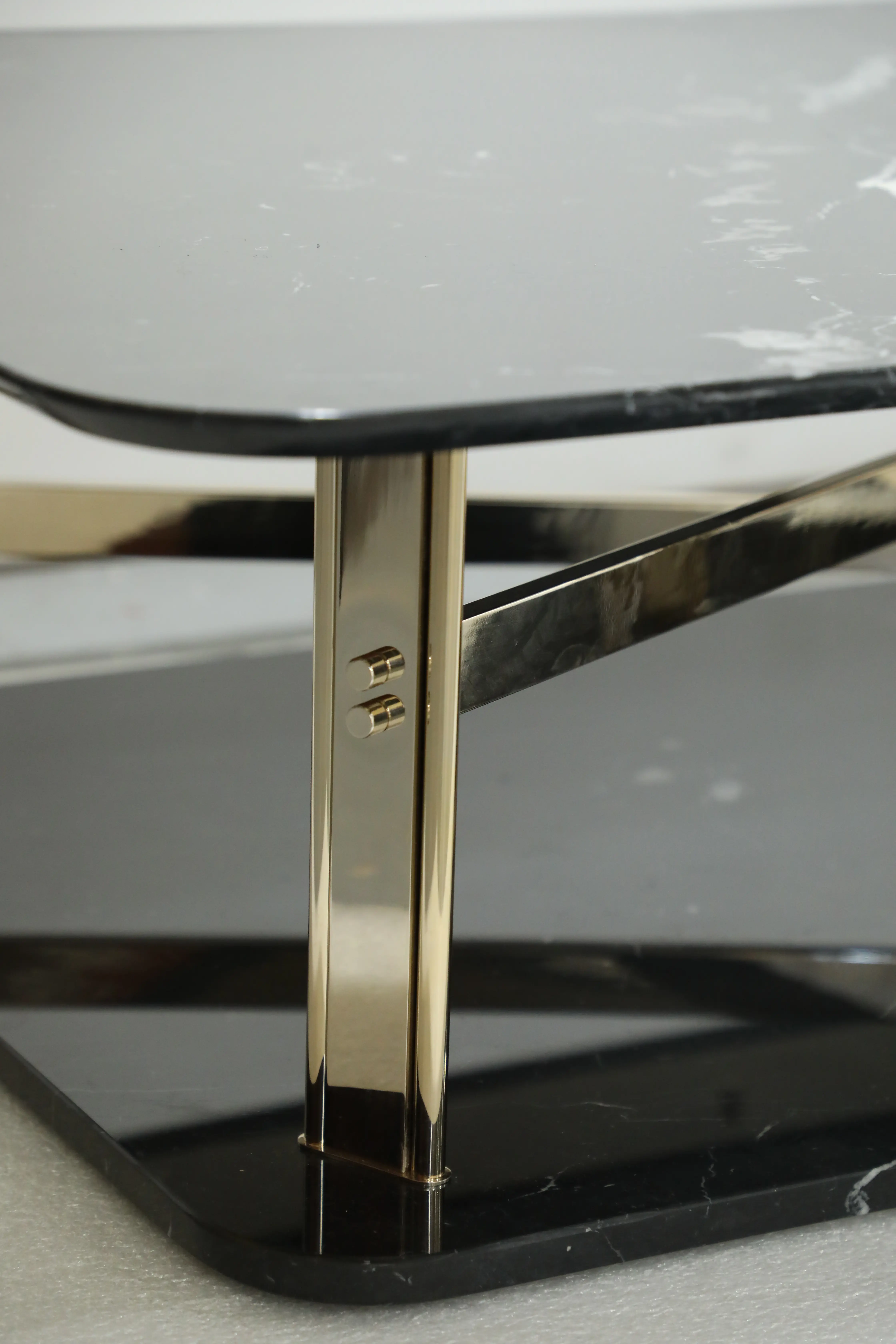 /storage/Luxury brass and marble center table with geometric columns, blending modern elegance and bold design for a refined, opulent living space.