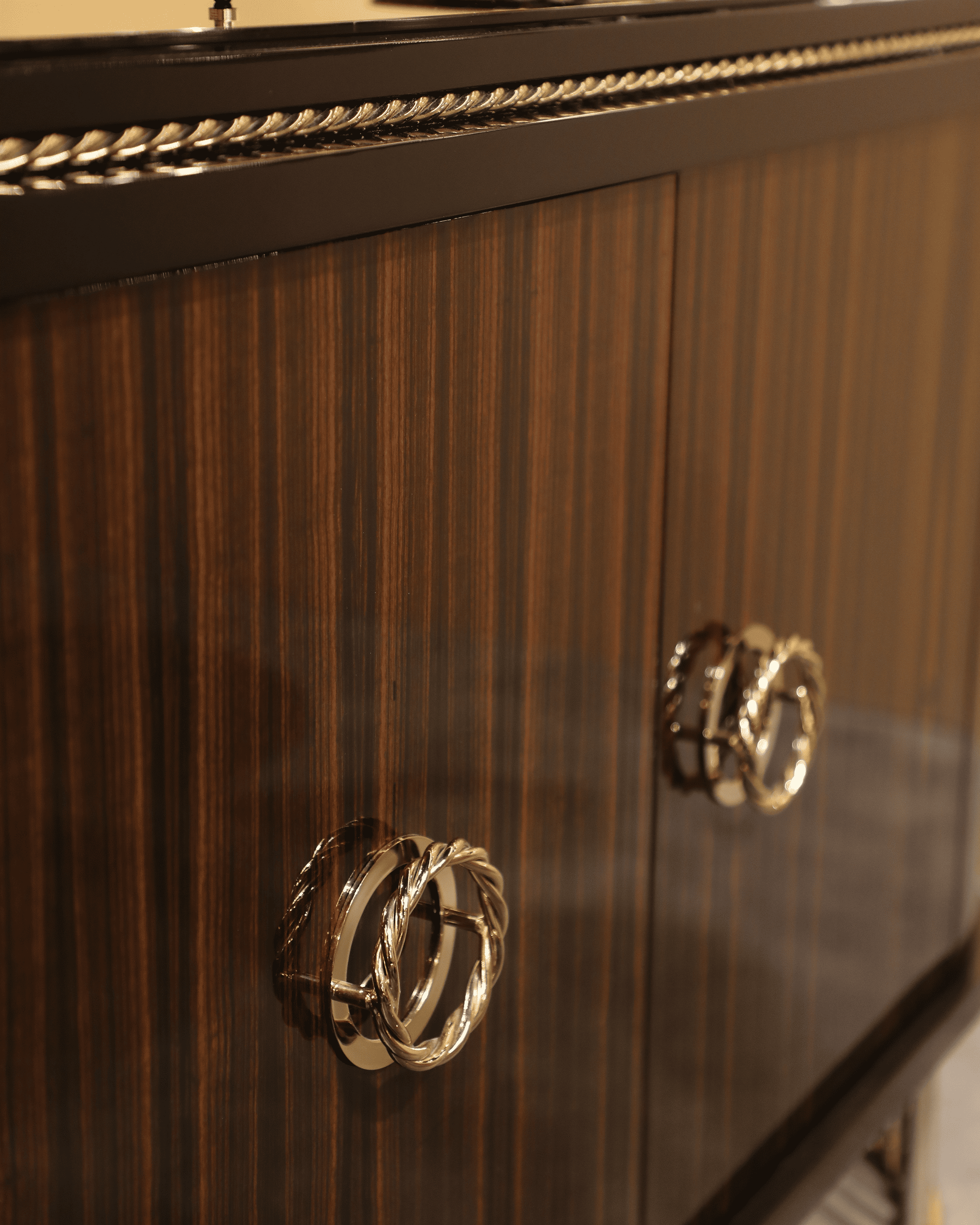 /storage/Luxury brass-accented Nautilus sideboard in ebony veneer with glass details, a modern classic design exuding naval inspiration and sophisticated elegance.
