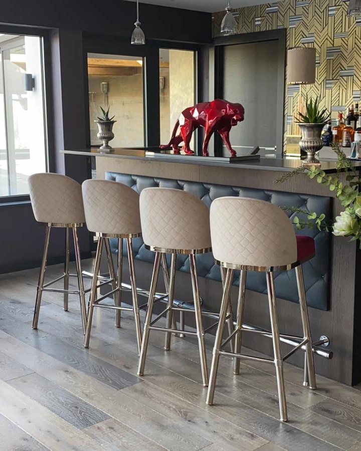 /storage/Luxury brass bar chair with gold-plated legs, black nickel accents, and curved upholstered body, blending Art Deco style with modern femininity.