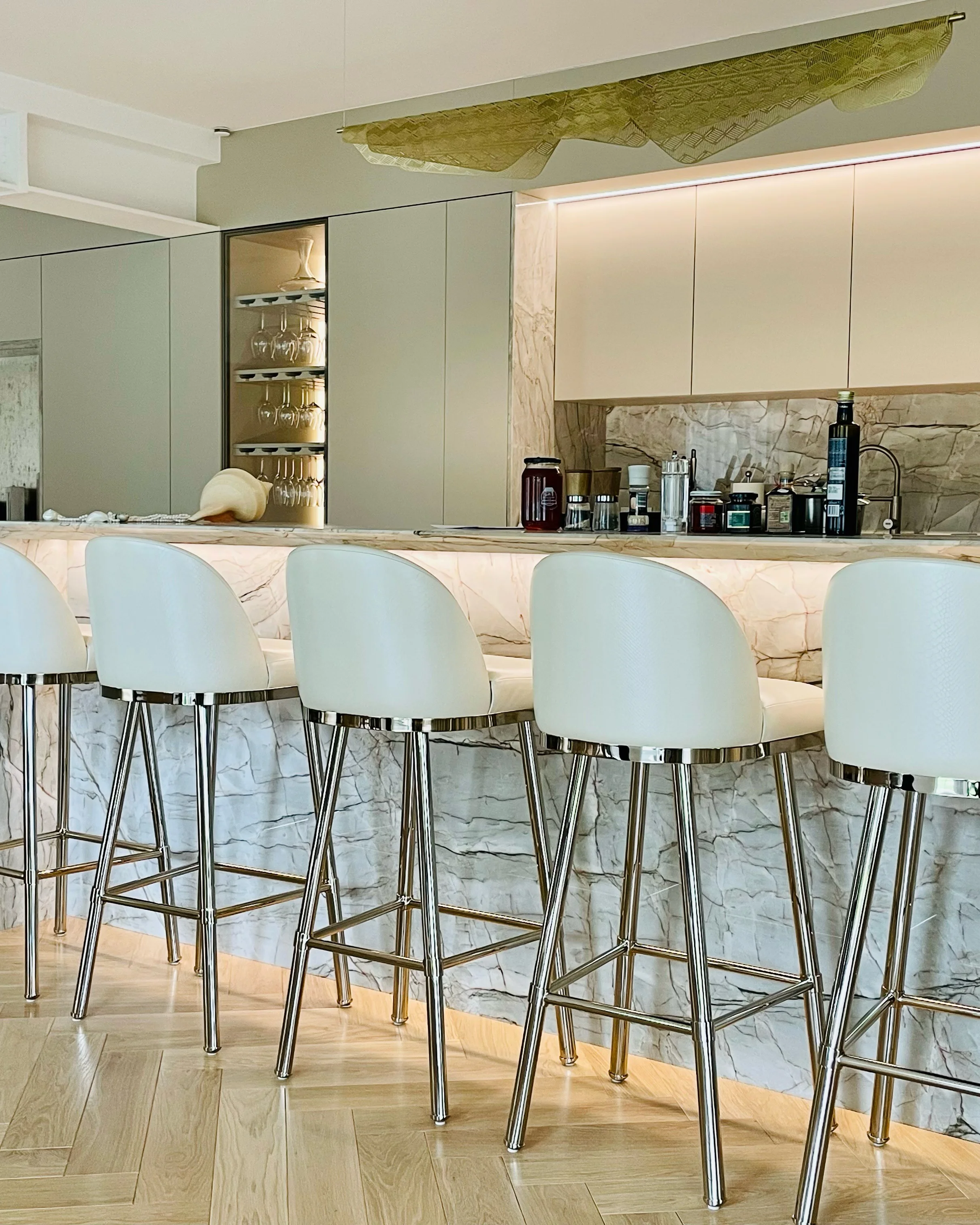 /storage/Luxury brass bar chair with gold-plated legs, black nickel accents, and curved upholstered body, blending Art Deco style with modern femininity.
