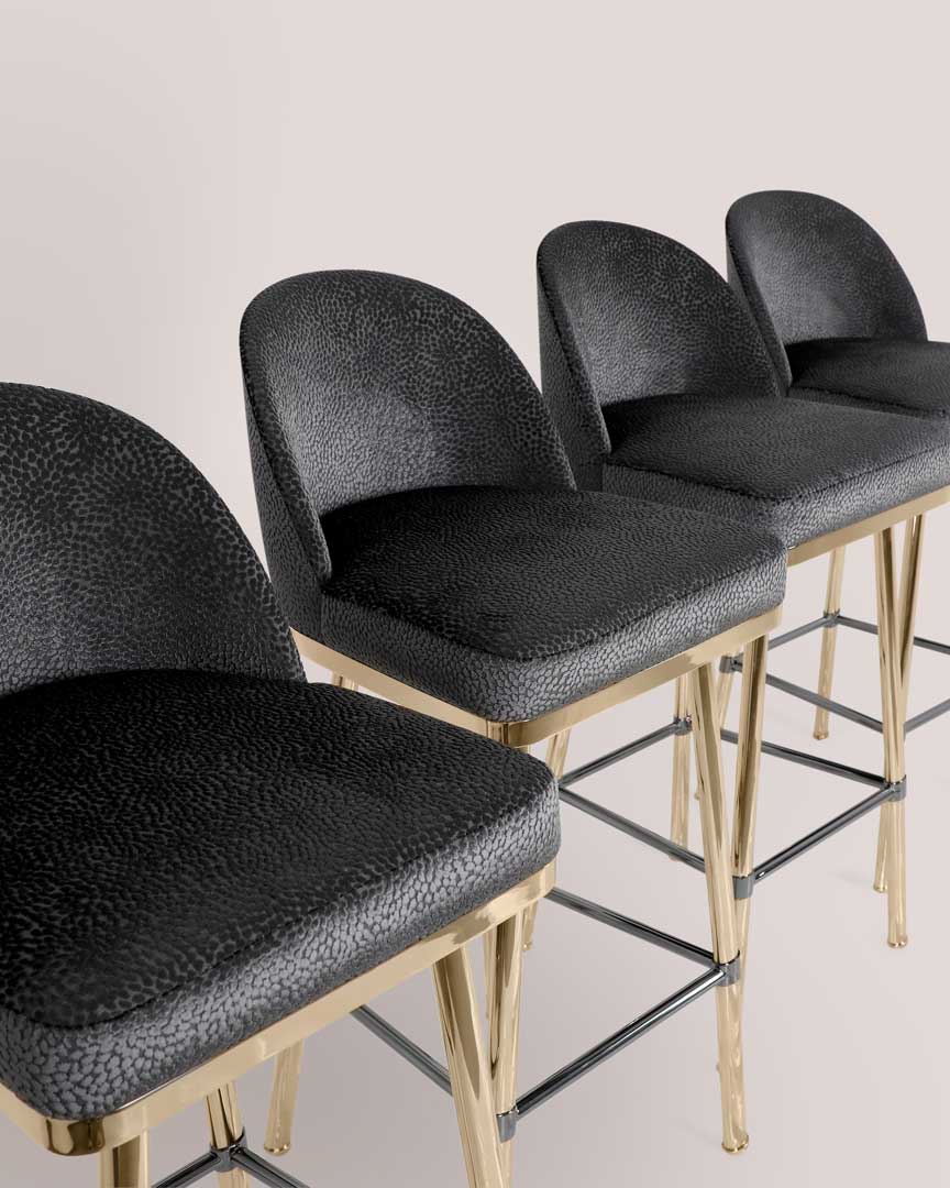 /storage/Luxury brass bar chair with gold-plated legs, black nickel accents, and curved upholstered body, blending Art Deco style with modern femininity.