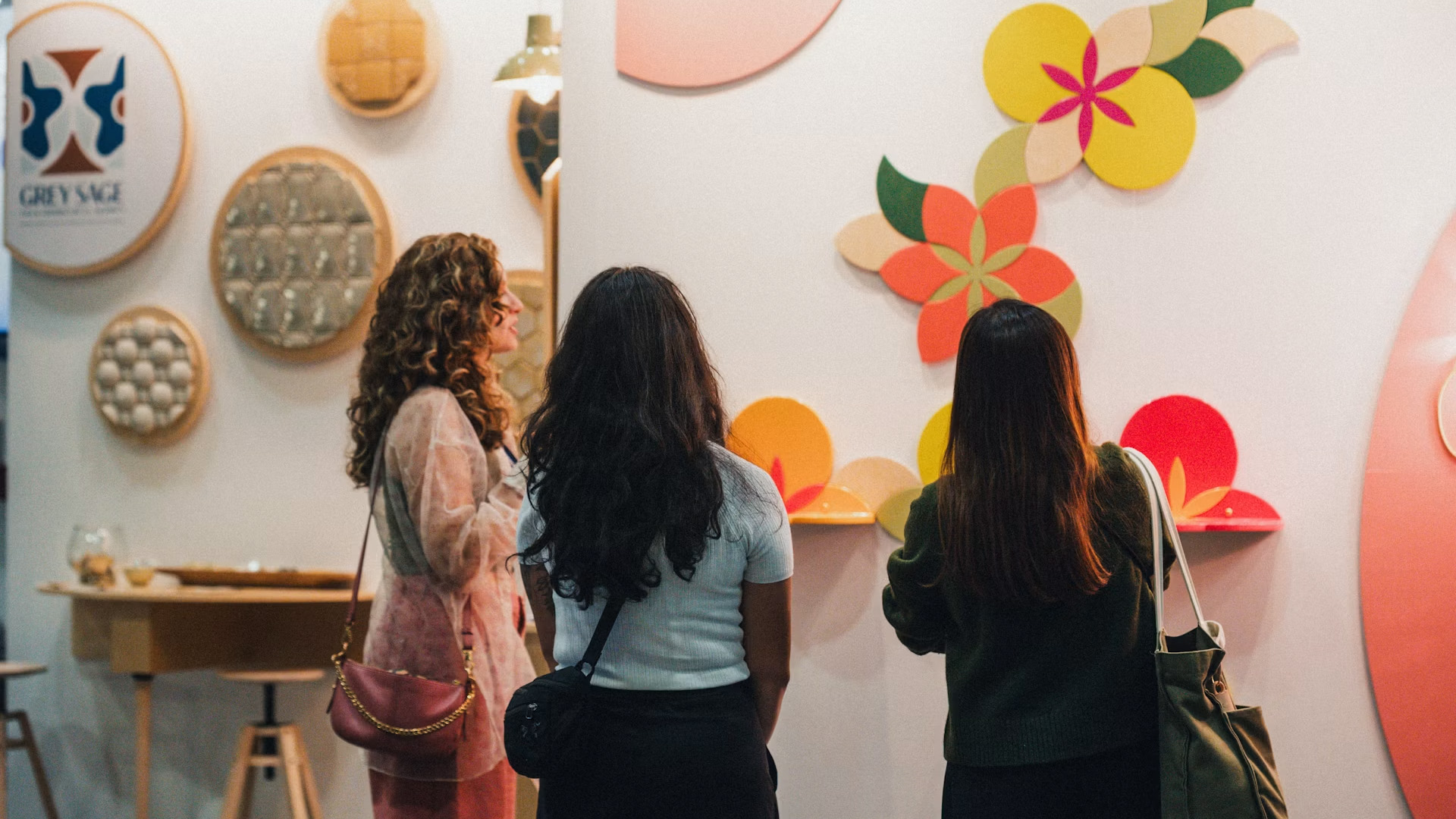 IDS Vancouver visitors exploring a colourful contemporary design installation with floral-inspired wall elements.
