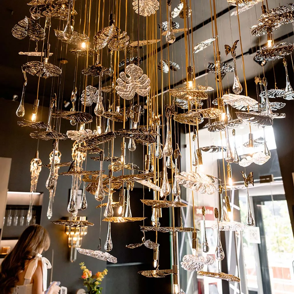 /storage/Luxury brass suspension with nature-inspired raindrop and butterfly details by Castro Lighting.
