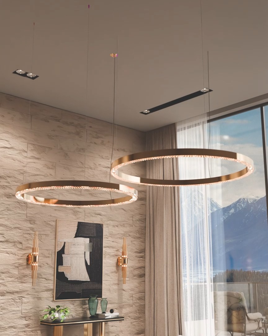 Close-up of the Métis Suspension handcrafted in brass with delicate crystal accents, illuminating a contemporary interior transitioning from summer to autumn with layered autumn tones.